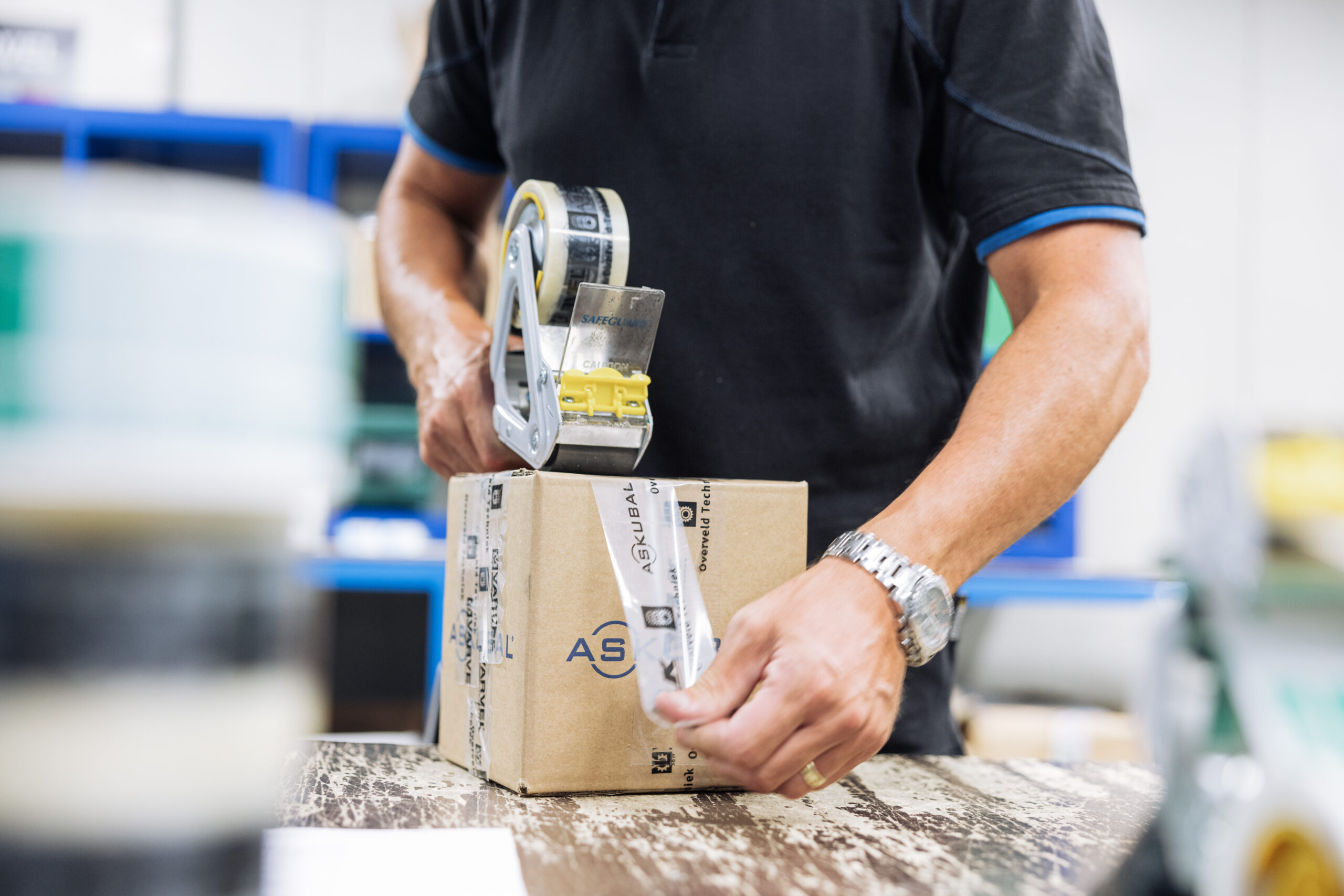 magazijn medewerker van Overveld techniek pakt een pakketje in